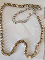 Full view of the jeweled decorative belt showing yellow-golden rhinestones linked by silver-tone metal.