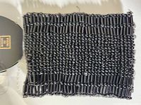 Top-down photo of black beaded bracelet showing alternating cylindrical and round beads closely arranged.