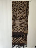 Full scarf hanging to show length, pattern combining leopard and zebra prints.