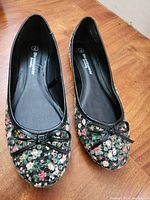 Top view of the pair of Street Wear Society women's flats showing floral pattern and bow on toes