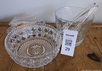 Photo of crystal serving bowl and ice bucket with tongs on wooden surface, showing clear intricate cut glass designs