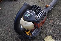 Close-up of the Homelite blower motor housing showing the brand label and model details with minor wear and dirt.