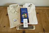 Photo showing all items in the lot: white Saddles shirt, tan LL Bean shirt, Peanuts holiday tie, and belt in packaging.