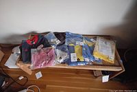 Photo showing selection of athletic apparel items including Adidas Boston Marathon gear, New England Revolution jacket, and AX polo shirt placed on a wooden tray.