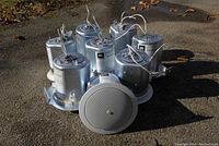 Eight JBL Professional Ceiling Loudspeakers Control 24CT shown from front with white speaker grills and wiring.