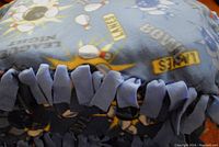 Close-up of the fringed fleece edge showing tied knots and blue bowling themed fabric.