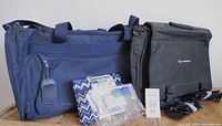 Two travel bags (one navy blue, one black) and assorted toiletry items including empty liquid containers and a blue and white chevron toiletry bag.