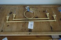 Full set displayed on wooden surface showing two towel rods and one towel ring.