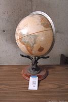 Full view of the vintage globe showing the map details and wooden base.
