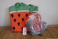 Photo showing the watermelon-themed beach cooler bag next to the Topshop watermelon-shaped woven straw purse in original plastic packaging.