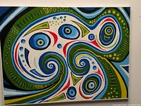 Front view of a colorful abstract painting with swirling blue, green, red, and yellow shapes on a white canvas.