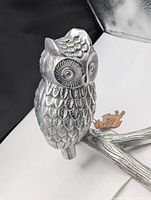 Close up photo of cast aluminum owl figurine showing detailed feather pattern and eyes.