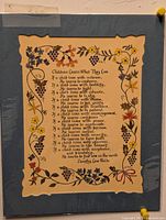 Image of an 8x10 print mounted on blue mat board showing the poem 'Children Learn What They Live' by Dorothy Law Nolte with floral border decoration.