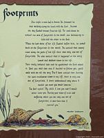 Photo of the decorative print titled 'footprints' with whimsical turtle and bird illustrations, mounted on dark backing.