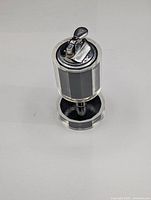 Front angled view of vintage table lighter showing clear acrylic top and bottom sections with black panels in between and chrome lighter mechanism on top.