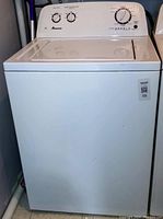 Front view of white Amana top-load washer with control panel and closed lid