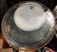 Bass drum head with visible wear and Remo logo on it.