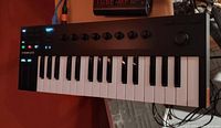 Native Instruments Komplete Kontrol M32 keyboard controller showing keys, knobs, buttons, and display.