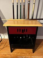 Pool cues on and near the stand, showing overall set and stand design.