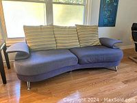 Full front view of vintage 1960's style blue couch with three striped cushions.