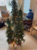 Front view showing three artificial trees of varying heights with lights