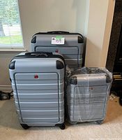 Three cases grouped on floor showing small case in plastic wrap in front of medium and large cases