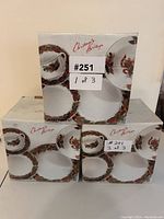 Three boxed Christmas Heritage 20-piece dinner sets stacked, each box labeled 1 of 3, 2 of 3, and 3 of 3, showing total 60 pieces for 12 people.