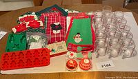 Full contents including glass mugs, kitchen towels, pot holders, silicone baking molds, cookie cutters, and boxed liners arranged on table