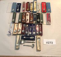 Collection of 27 commemorative spoons mostly in presentation boxes, arranged on white background with lot number card.