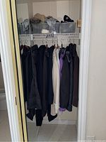 Closet overview showing ten hanging jackets and two clear bins on shelf
