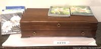 Closed wooden silverware box with floral napkins on each side.