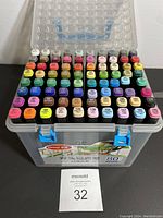Top-down view of 80 assorted color markers neatly arranged in plastic case showing cap colors and numbers visible.