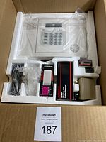 Full view of the Ademco security system kit including the control panel, motion sensor, power supply, battery, and mounting bracket in white foam packaging.