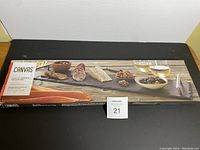 Image of the boxed glass serving platter brand Canvas, showing product packaging and use example with food items.