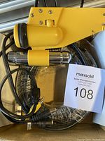 Yellow underwater camera housing with attached cables and underwater light accessory packed in clear plastic inside a box.