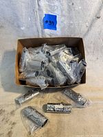 Box with multiple individually bagged silver lighter covers with unicorn design.