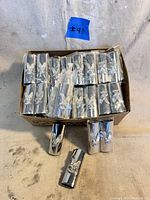 Box with multiple silver toned vintage Bic lighter covers featuring an eagle in relief, still in original packaging.