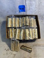 Box of 45 individually wrapped gold-toned lighter covers with embossed ornamental swirling pattern and GREYHOUND logo.