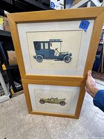 Frontal view of both vintage automobile prints in matching light wood frames, showing full display of size and framing.