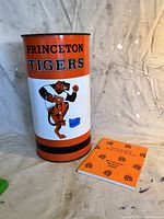 Photo of Princeton University Tigers metal trash can and 2000 yearbook together on a light surface