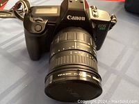 Front view of Canon EOS 630 camera with Sigma 28-200mm zoom lens attached showing lens markings and camera body details.