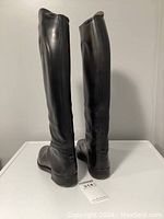 Front and back views of tall black leather riding boots showing overall condition and shape