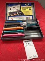 Full view of the open Gatco Edgemate Diamond Sharpening System case showing color-coded sharpening hones, honing oil, and instructions.