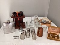 Overview of collection showing flask, pipes with stand, shot glasses, silver-plated nesting shot glasses, shaver and cufflinks.