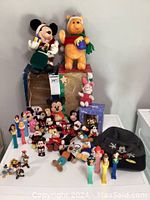 Wide shot of the collection arranged on a table showing variety of animated ornaments, plush toys, PEZ dispensers, and the duffle bag