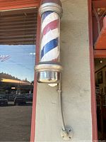 Front view of barber pole sign mounted on exterior wall