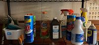 Shelf holding assorted cleaning products including Ajax cleaner, Spic and Span, Hydrogen Peroxide, Lysol, and WD-40 among others.