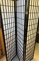 Front view of four-panel black wooden frame Shoji screen with white paper, showing the general structure and slight wear.