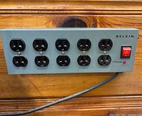 Front view of Belkin metal outlet panel with 10 outlets and red power switch