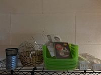 Variety of assorted containers on a black metal shelving unit against a beige wall